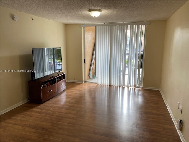 unfurnished living room featuring a textured ceiling, a healthy amount of sunlight, and dark hardwood / wood-style flooring