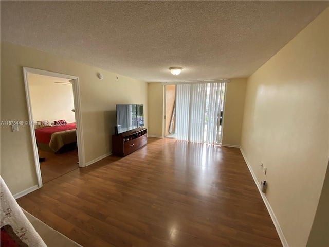 living room with a textured ceiling and dark hardwood / wood-style flooring