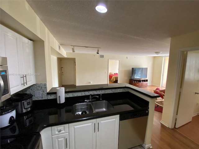 kitchen featuring sink, a textured ceiling, white cabinetry, appliances with stainless steel finishes, and light hardwood / wood-style floors