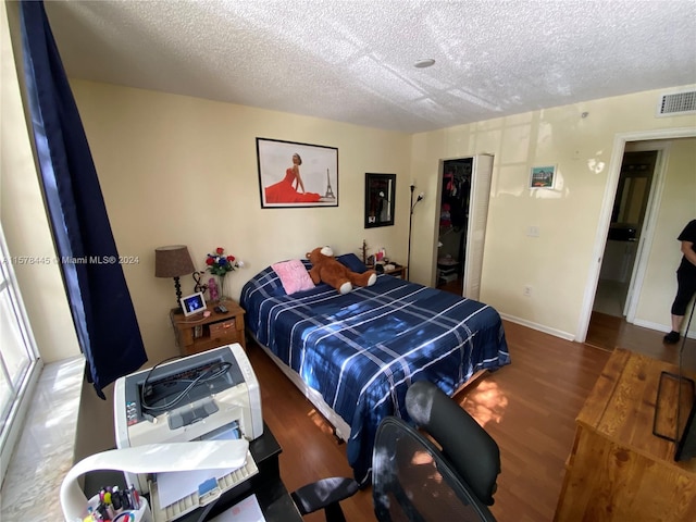 bedroom featuring a textured ceiling and hardwood / wood-style flooring