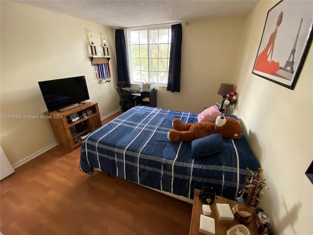 bedroom featuring a textured ceiling and hardwood / wood-style floors