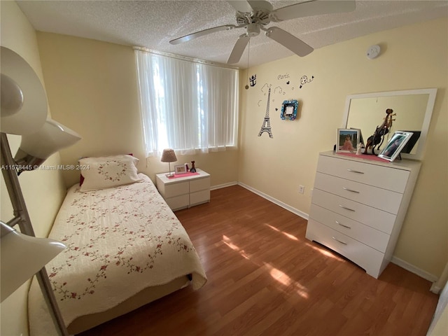 bedroom featuring a textured ceiling, dark hardwood / wood-style floors, and ceiling fan