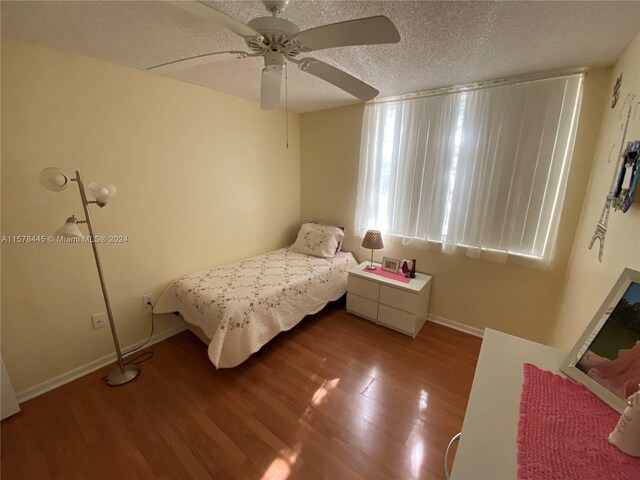 bedroom featuring a textured ceiling, ceiling fan, and hardwood / wood-style flooring