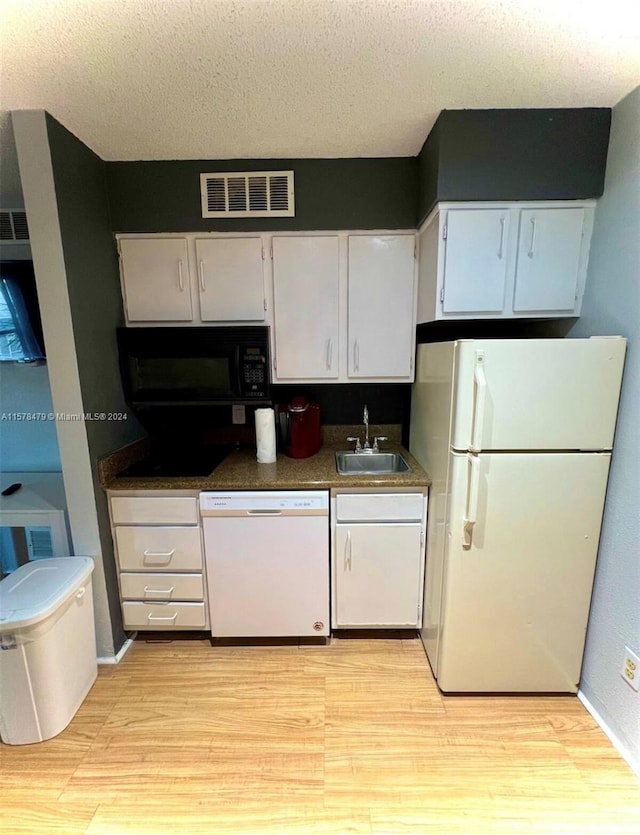 kitchen featuring white appliances, light wood-type flooring, sink, and white cabinetry