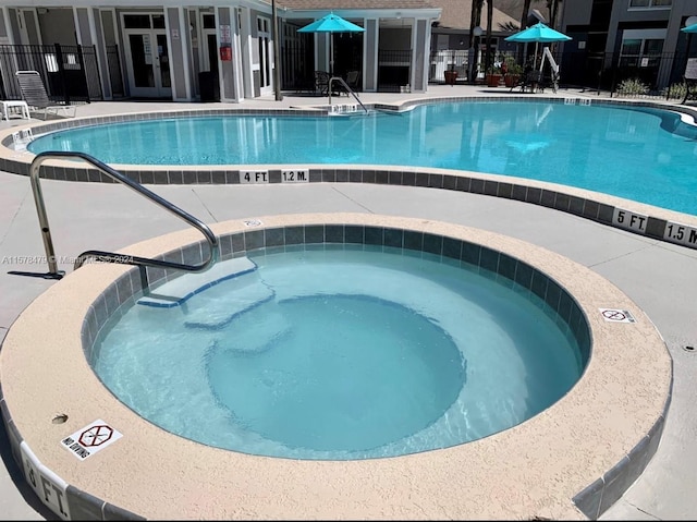 view of pool with a patio area and a community hot tub