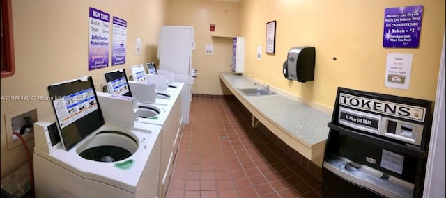 laundry room featuring sink and dark tile flooring