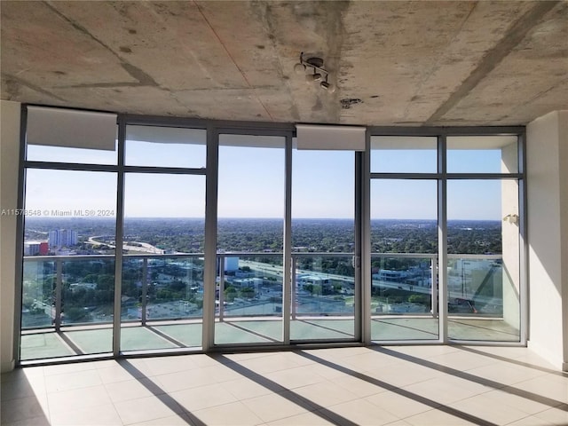 tiled empty room featuring expansive windows