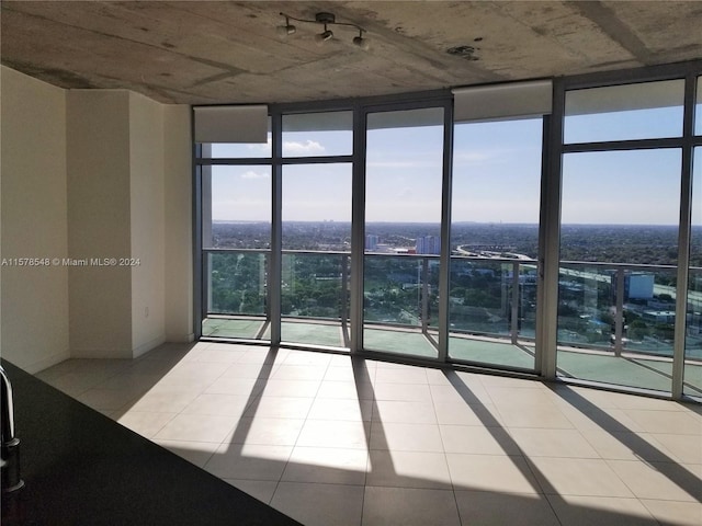 tiled empty room featuring expansive windows