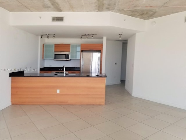 kitchen featuring appliances with stainless steel finishes, sink, and light tile floors