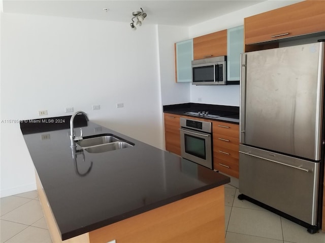 kitchen featuring appliances with stainless steel finishes, sink, light tile floors, and a kitchen island