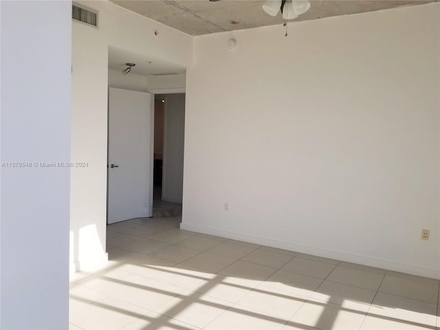 spare room with light tile flooring and ceiling fan