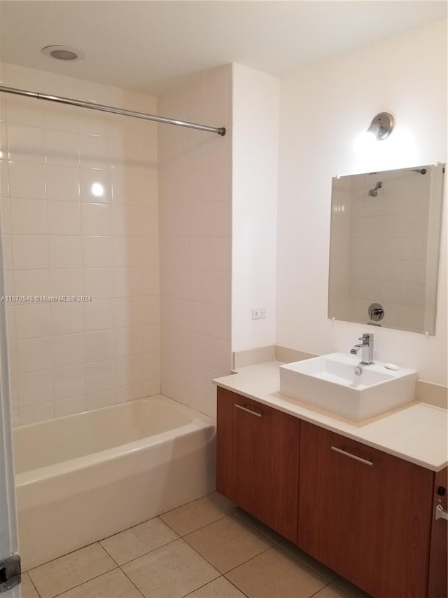 bathroom featuring tile flooring, vanity, and tiled shower / bath