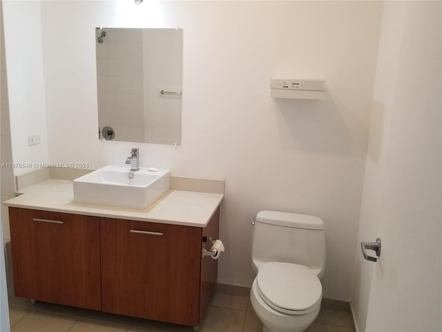 bathroom featuring tile flooring, vanity, and toilet