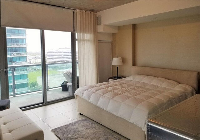 bedroom featuring access to outside, light tile flooring, and multiple windows