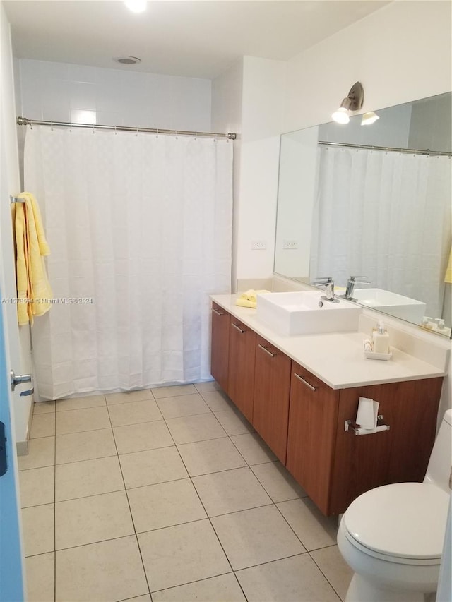 bathroom with tile floors, toilet, and vanity