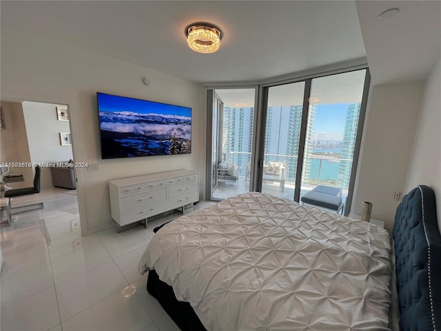 bedroom featuring light tile patterned floors, access to exterior, and a wall of windows