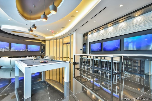 game room with a raised ceiling, billiards, and dark tile patterned floors