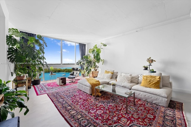 living room with expansive windows, a water view, and concrete floors