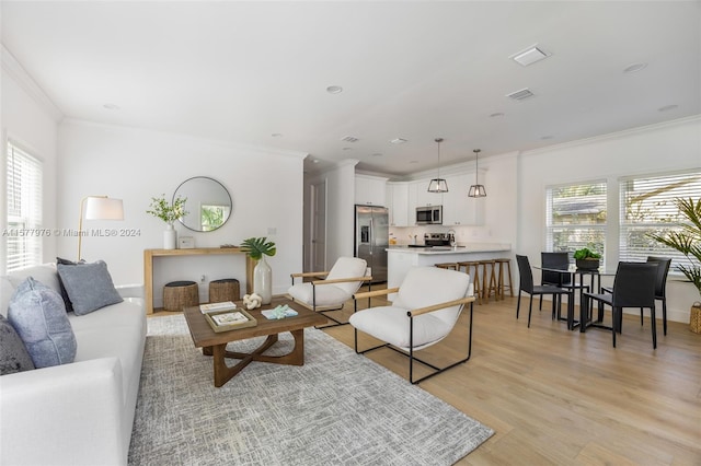 living room featuring a healthy amount of sunlight, light hardwood / wood-style flooring, and ornamental molding