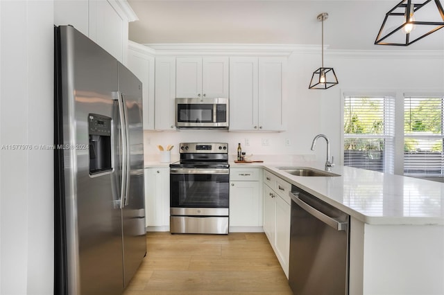 kitchen with pendant lighting, white cabinets, light hardwood / wood-style flooring, appliances with stainless steel finishes, and sink