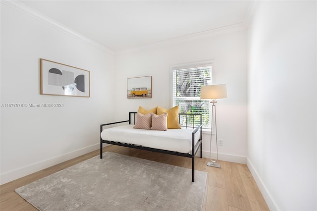 sitting room with hardwood / wood-style flooring and ornamental molding