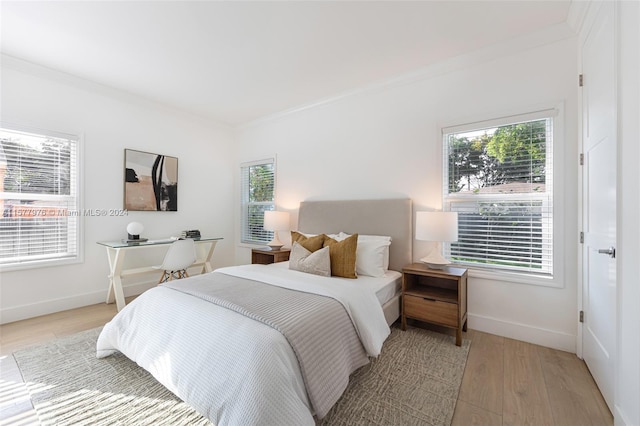 bedroom with light hardwood / wood-style floors and crown molding