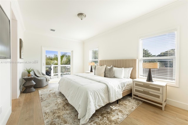 bedroom featuring multiple windows, access to exterior, and light wood-type flooring