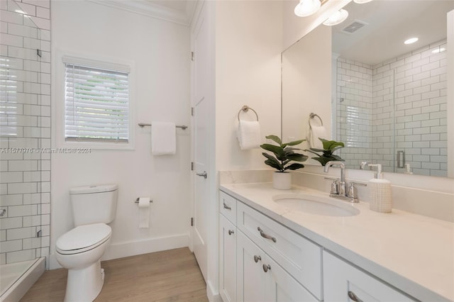 bathroom featuring wood-type flooring, vanity, toilet, and ornamental molding