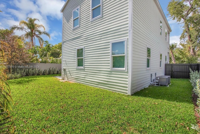 exterior space with central air condition unit and a lawn