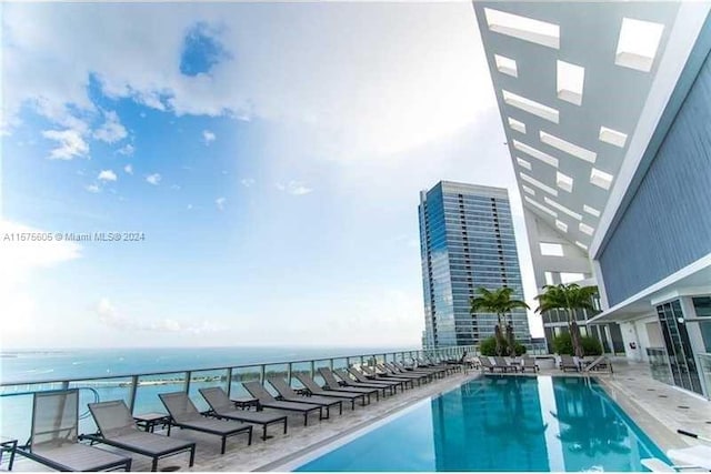 view of swimming pool featuring a patio area and a water view