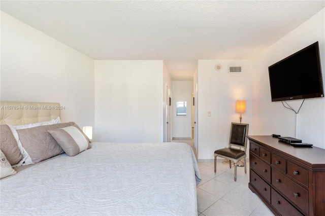 bedroom with a textured ceiling and light tile patterned flooring