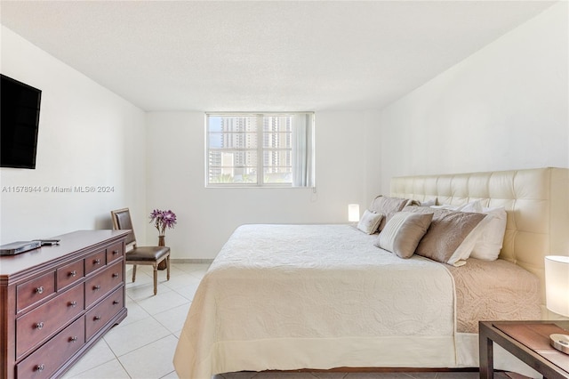 bedroom featuring light tile patterned floors and a textured ceiling