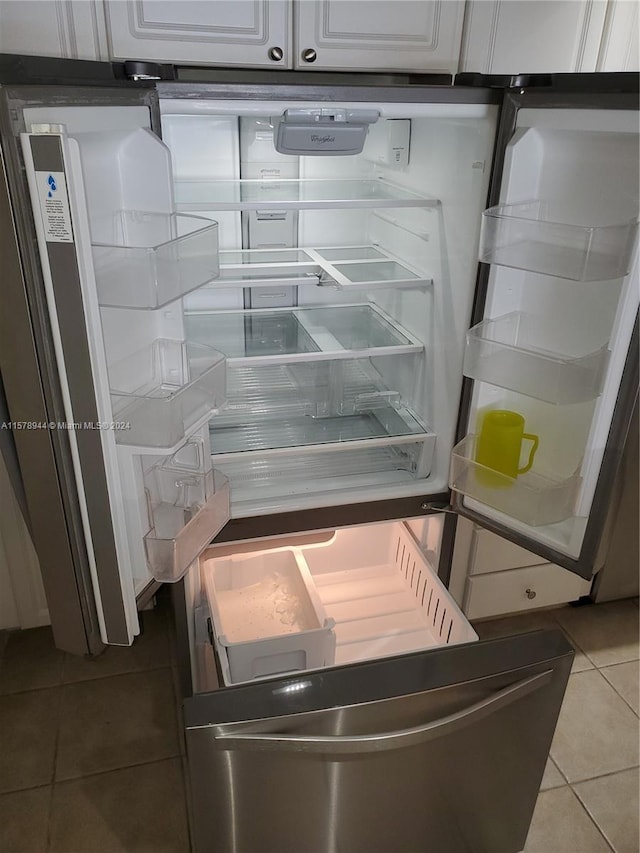 room details featuring refrigerator and white cabinets