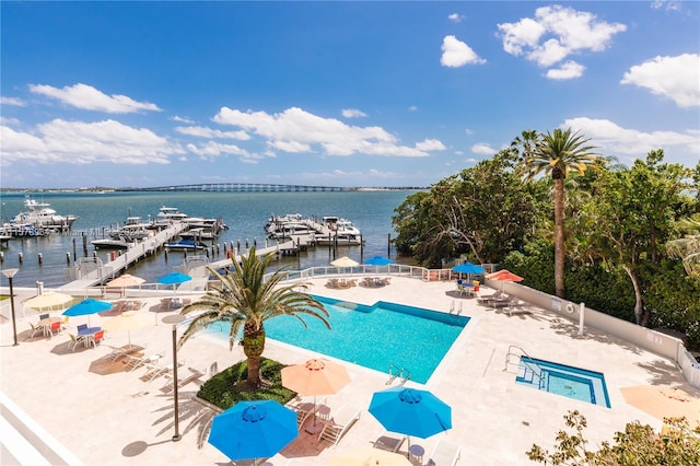 view of pool with a boat dock and a water view