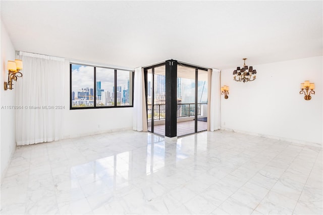 tiled spare room with floor to ceiling windows and a notable chandelier