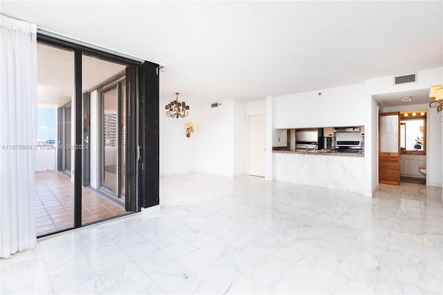 unfurnished living room with a notable chandelier and light tile floors