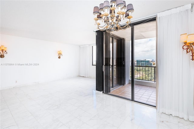 tiled empty room featuring a chandelier and a wall of windows