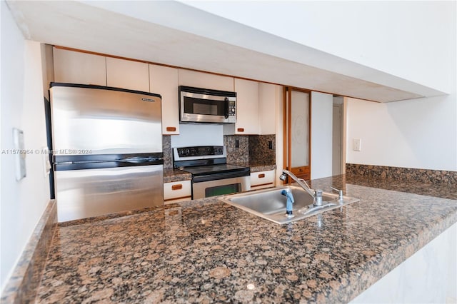 kitchen featuring white cabinets, sink, appliances with stainless steel finishes, and dark stone countertops