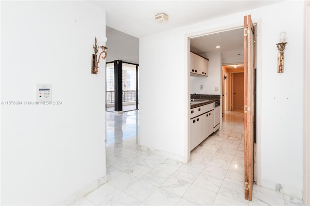 corridor featuring sink and light tile flooring