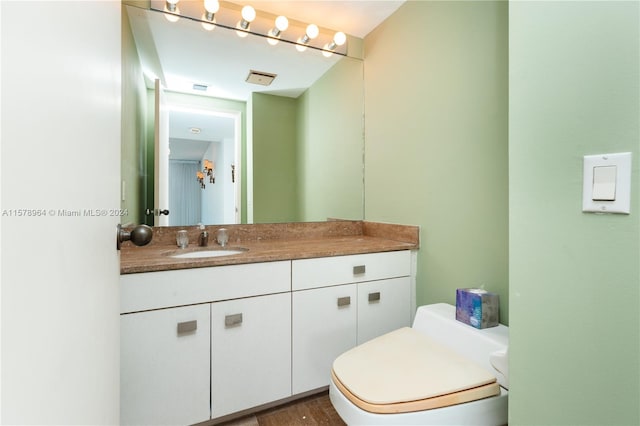 bathroom featuring wood-type flooring, vanity, and toilet