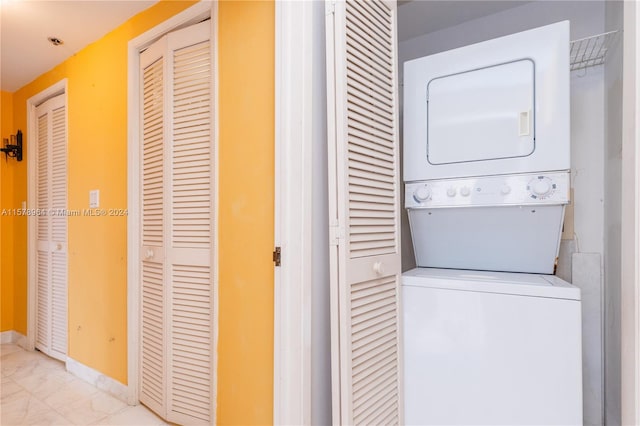 laundry room with light tile floors and stacked washer / drying machine