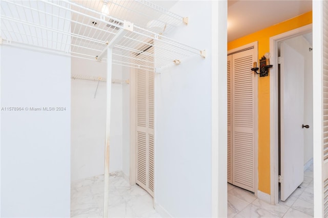 walk in closet with light tile flooring