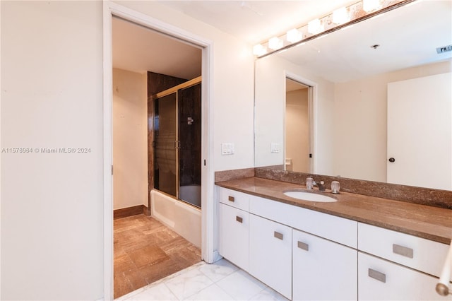 bathroom with vanity, bath / shower combo with glass door, and tile flooring