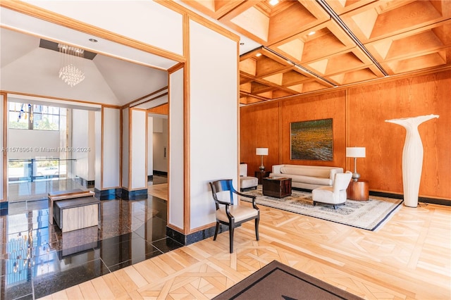 living room with coffered ceiling, wood walls, beam ceiling, and a notable chandelier