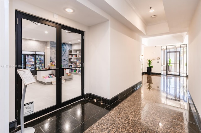 corridor featuring a raised ceiling and dark tile flooring