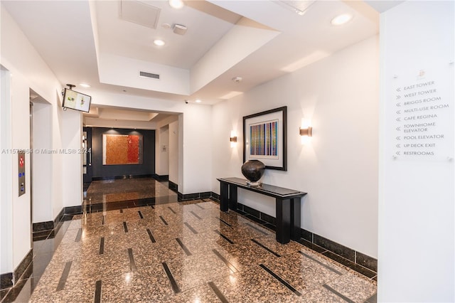 hallway featuring a tray ceiling