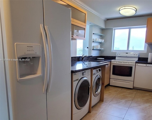 kitchen featuring white appliances, washer and clothes dryer, ornamental molding, light tile floors, and sink