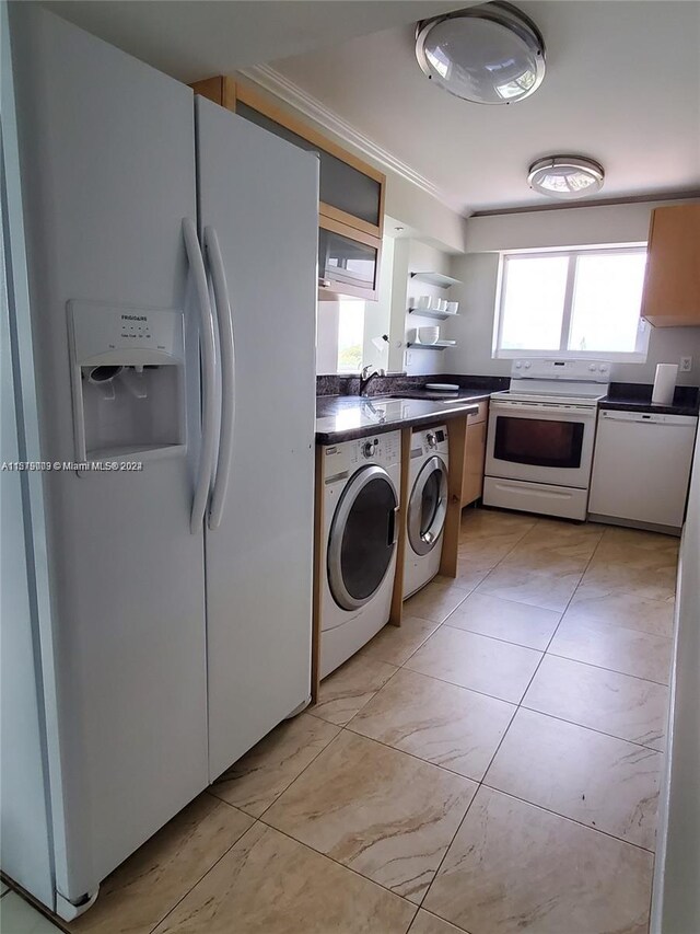 clothes washing area featuring sink, light tile floors, and washer and clothes dryer