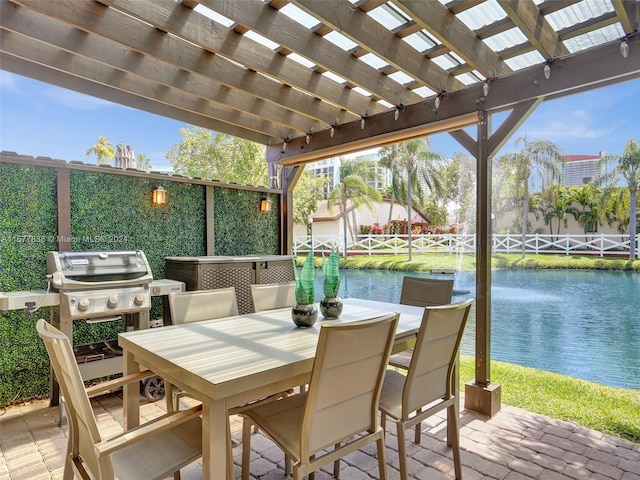 view of terrace with area for grilling, a pergola, and a water view