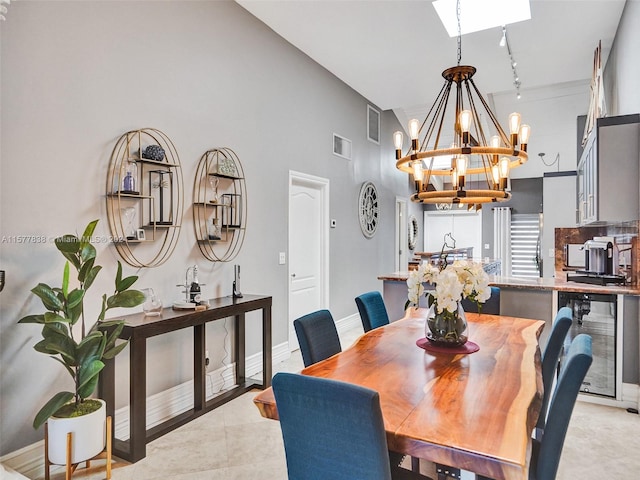 dining room featuring a chandelier, high vaulted ceiling, light tile flooring, and beverage cooler